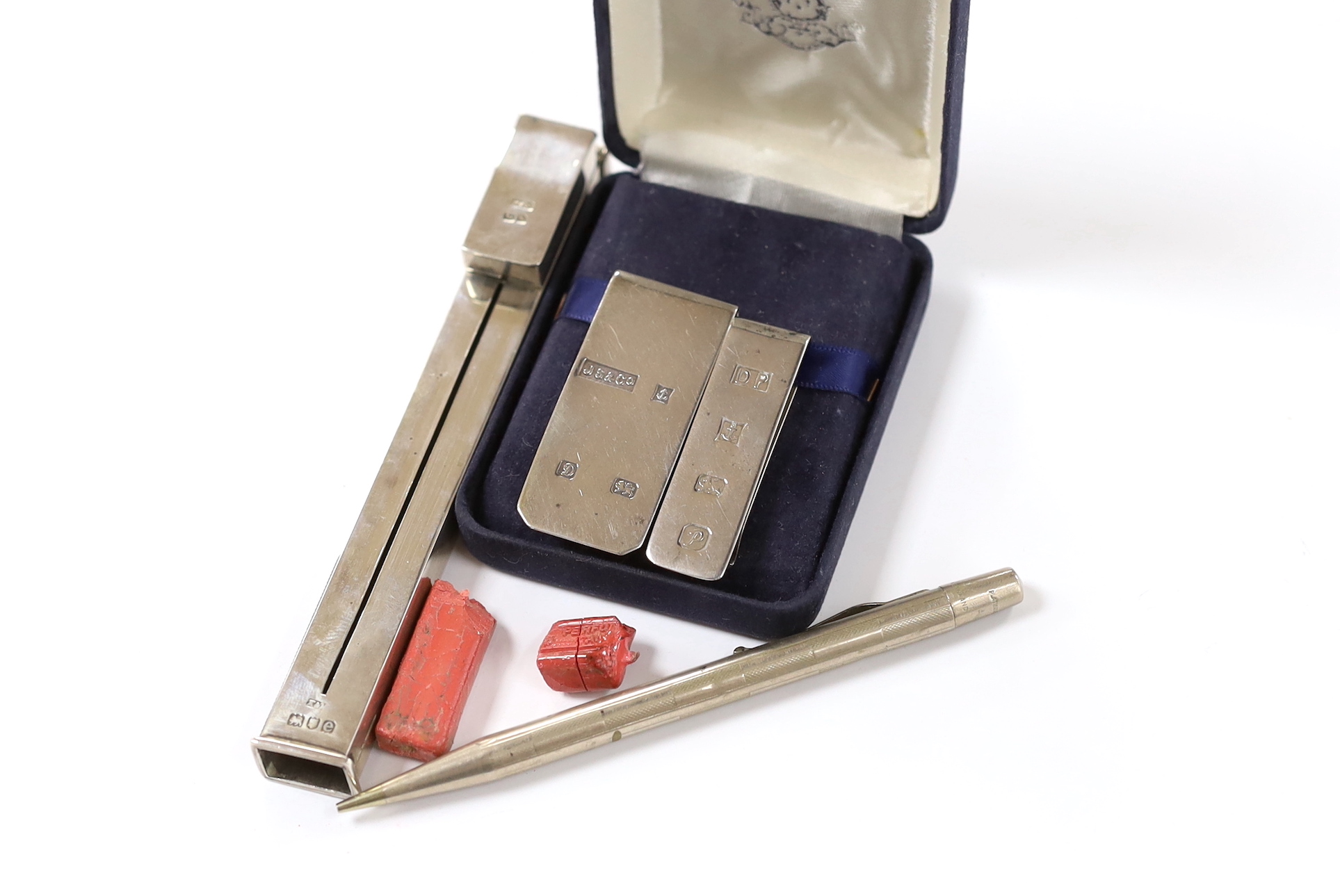 An Edwardian silver propelling wax seal dispenser/vesta, Birmingham, 1904, 13.7cm, two modern silver money clips and a Yard-O-Lead pencil.